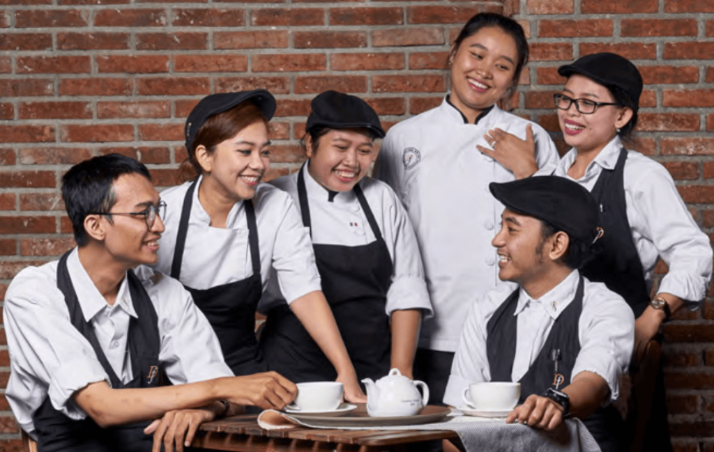 Equipe souriant autour d'une tasse de thé